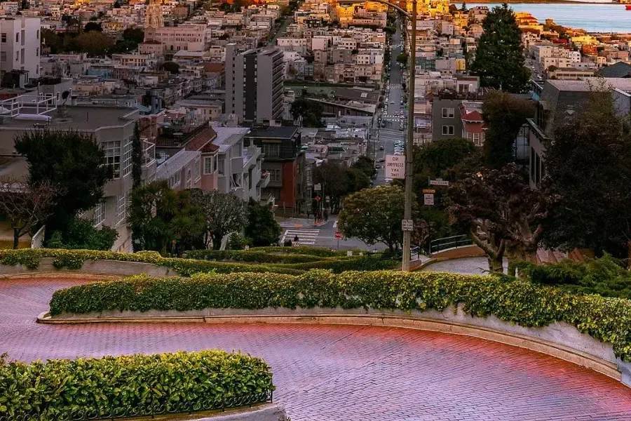 Lombard Street curves with 又帮 in the distance during sunset.